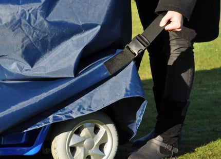 Man securing a durable scootmobiel hoes with a strap to protect against rain and dirt.